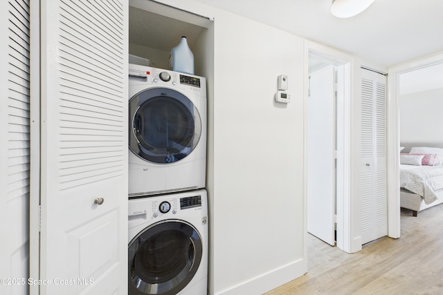 6365 Bahia Del Mar Blvd S Unit 210, Saint Petersburg, FL 33710 - laundry room with stacked washer and dryer, baseboards, laundry area, and light wood-type flooring