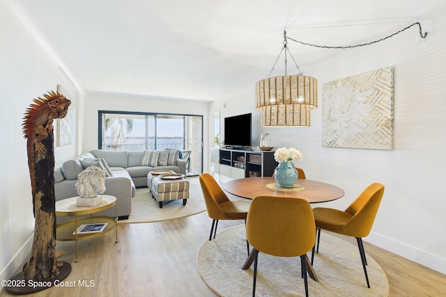 6365 Bahia Del Mar Blvd S Unit 210, Saint Petersburg, FL 33710 - dining space with baseboards, a notable chandelier, and light wood-style flooring