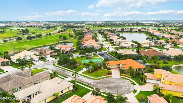 drone / aerial view with golf course view, a residential view, and a water view