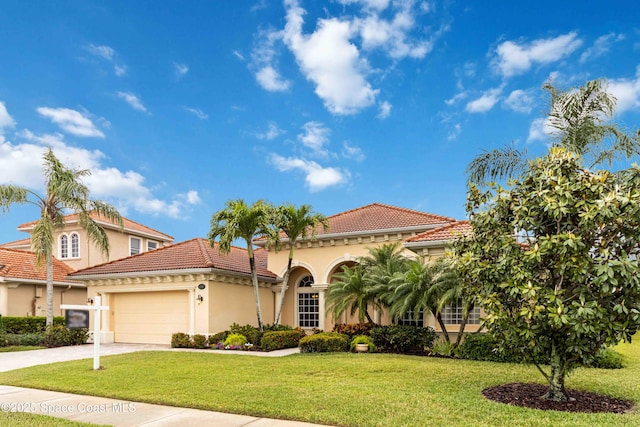 mediterranean / spanish home featuring a tiled roof, stucco siding, a front lawn, an attached garage, and concrete driveway