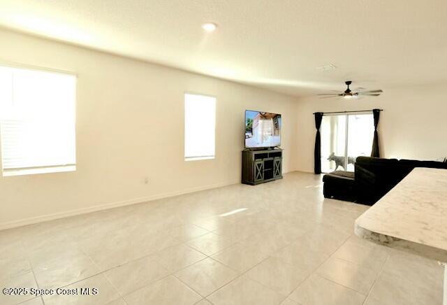 1217 Casey Ave, Rockledge, FL 32955 - living area featuring baseboards, a ceiling fan, and a wealth of natural light