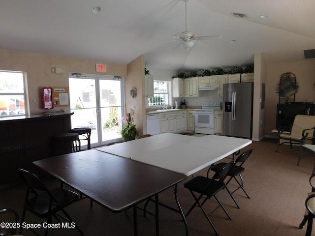8903 Laguna Ln Unit 403, Cape Canaveral, FL 32920 - dining room with vaulted ceiling, a ceiling fan, and light colored carpet