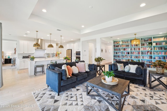2257 Kamin Dr, Melbourne, FL 32940 - living area featuring visible vents, recessed lighting, a raised ceiling, and light wood finished floors