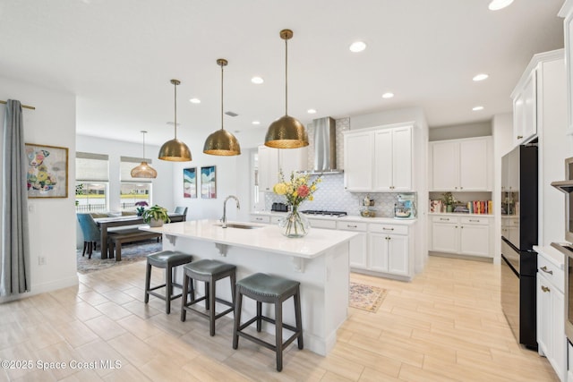 2257 Kamin Dr, Melbourne, FL 32940 - kitchen with light countertops, backsplash, a center island with sink, wall chimney exhaust hood, and a sink