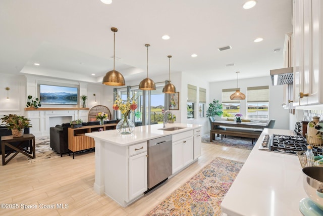 2257 Kamin Dr, Melbourne, FL 32940 - kitchen with white cabinets, a sink, light countertops, appliances with stainless steel finishes, and a center island with sink