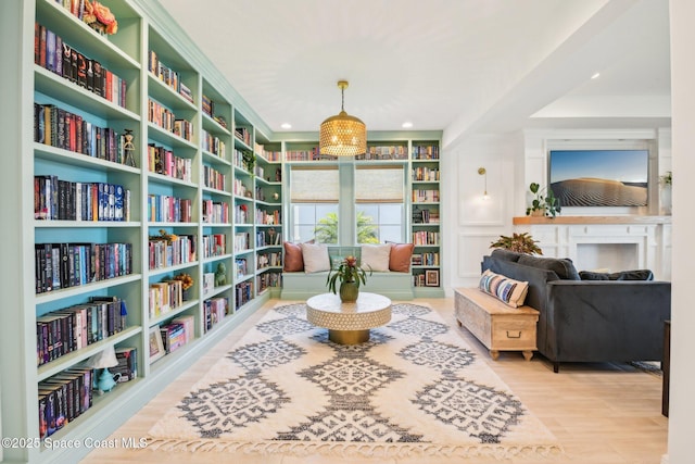2257 Kamin Dr, Melbourne, FL 32940 - sitting room with wall of books, built in features, recessed lighting, and wood finished floors