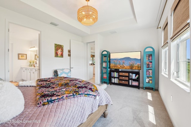 2257 Kamin Dr, Melbourne, FL 32940 - carpeted bedroom with visible vents, multiple windows, a tray ceiling, and ensuite bathroom