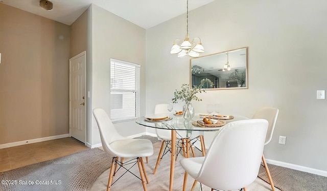 tiled dining room featuring baseboards and a chandelier