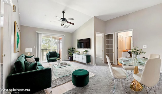 carpeted living room featuring visible vents, baseboards, a ceiling fan, and lofted ceiling