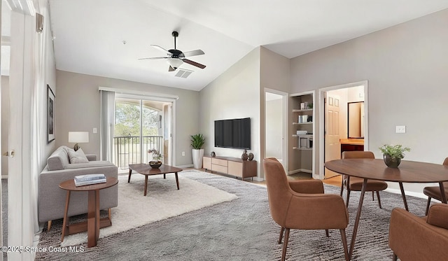 living area featuring visible vents, baseboards, vaulted ceiling, and ceiling fan