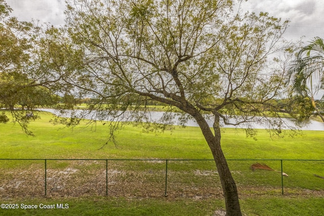 view of yard with fence and a water view