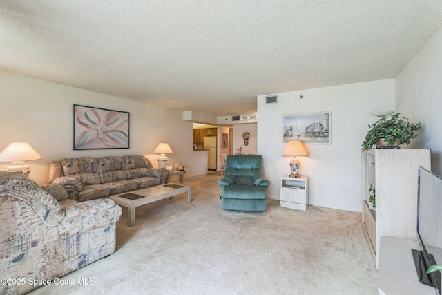 living room featuring a textured ceiling, visible vents, and carpet floors