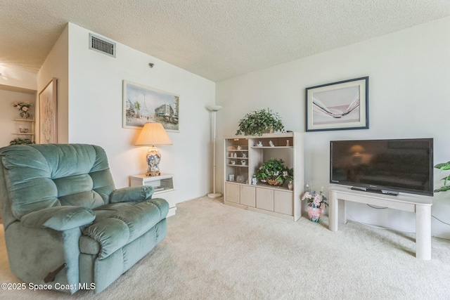 carpeted living room with visible vents and a textured ceiling