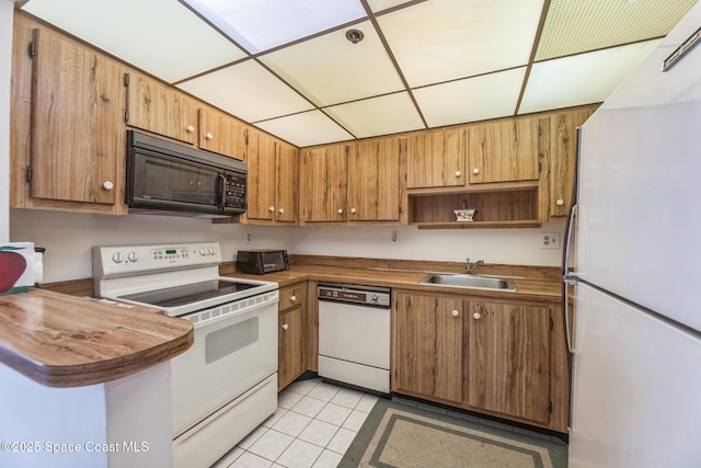 kitchen with white appliances, brown cabinetry, open shelves, light tile patterned flooring, and a sink