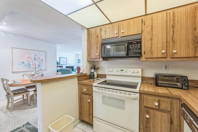 kitchen featuring brown cabinets, light tile patterned floors, light countertops, and white appliances