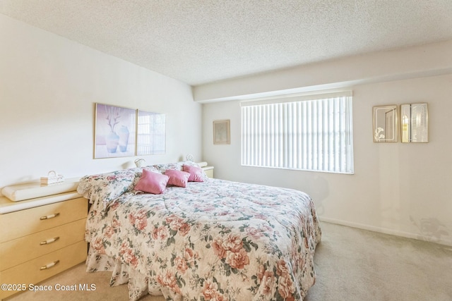 bedroom featuring baseboards, multiple windows, light carpet, and a textured ceiling