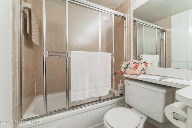 full bathroom with toilet and combined bath / shower with glass door