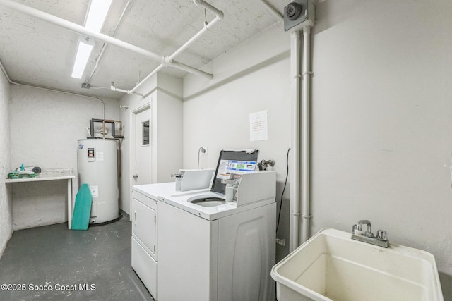 laundry area featuring electric water heater, washing machine and dryer, and a sink