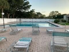 pool with a patio area and fence