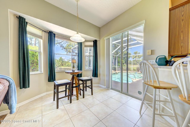 1772 Windbrook Dr SE, Palm Bay, FL 32909 - dining room with plenty of natural light, lofted ceiling, baseboards, and light tile patterned floors