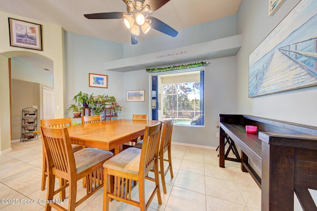 1772 Windbrook Dr SE, Palm Bay, FL 32909 - dining room featuring baseboards, arched walkways, a ceiling fan, and light tile patterned floors