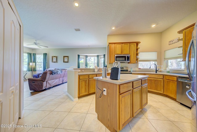 1772 Windbrook Dr SE, Palm Bay, FL 32909 - kitchen featuring open floor plan, a wealth of natural light, stainless steel appliances, light countertops, and a kitchen island