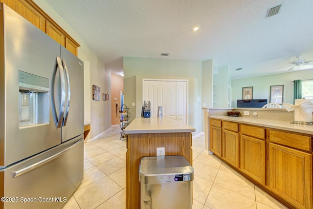 1772 Windbrook Dr SE, Palm Bay, FL 32909 - kitchen featuring stainless steel refrigerator with ice dispenser, light countertops, visible vents, and brown cabinetry