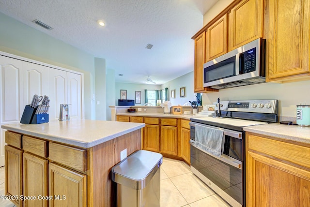 1772 Windbrook Dr SE, Palm Bay, FL 32909 - kitchen featuring stainless steel appliances, a peninsula, visible vents, and light countertops