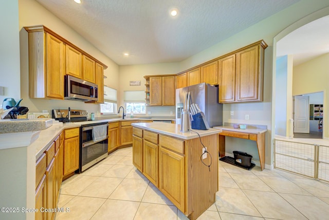 1772 Windbrook Dr SE, Palm Bay, FL 32909 - kitchen featuring light tile patterned floors, light countertops, a center island, and appliances with stainless steel finishes