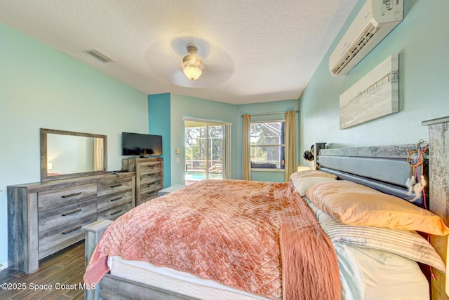 1772 Windbrook Dr SE, Palm Bay, FL 32909 - bedroom with dark wood finished floors, visible vents, a wall mounted AC, a textured ceiling, and access to outside