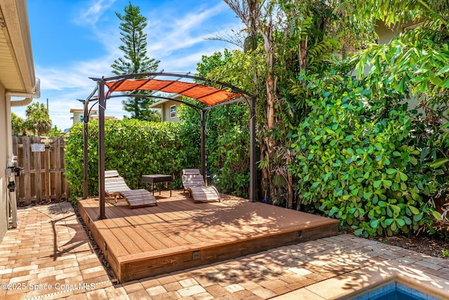 wooden terrace featuring fence, a pergola, and a patio
