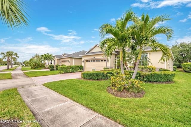 ranch-style home featuring an attached garage, driveway, stucco siding, and a front lawn