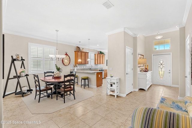 dining space featuring light tile patterned floors, visible vents, baseboards, and crown molding