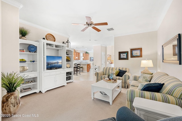 living area featuring crown molding, ceiling fan, light colored carpet, and visible vents