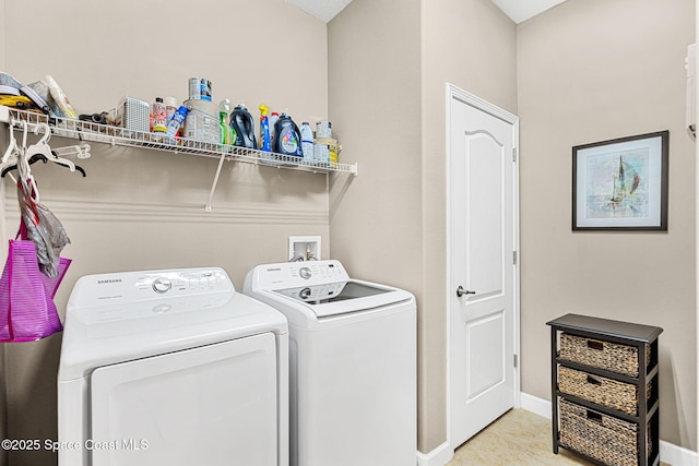 clothes washing area featuring light tile patterned floors, independent washer and dryer, laundry area, and baseboards