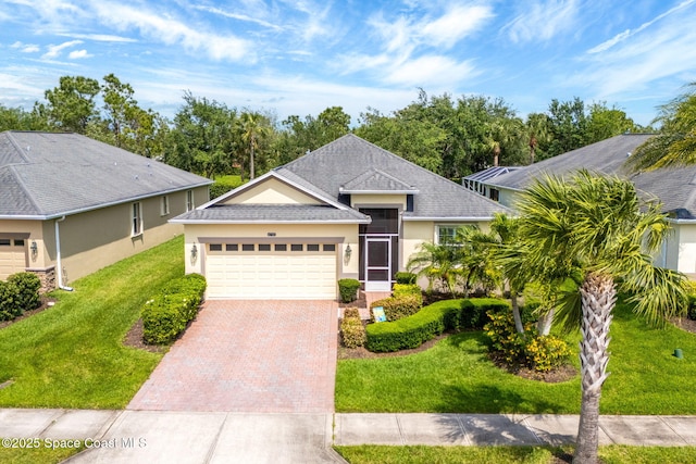 single story home with roof with shingles, stucco siding, decorative driveway, a front yard, and a garage