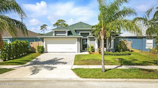 view of front of property featuring a front lawn, decorative driveway, stucco siding, and an attached garage