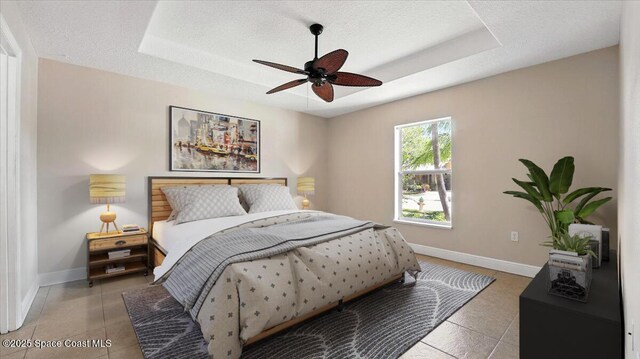 4191 Brantley Cir, Rockledge, FL 32955 - bedroom with baseboards, a raised ceiling, ceiling fan, and light tile patterned flooring