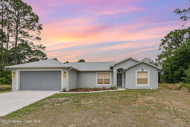 ranch-style house with stucco siding, a front lawn, driveway, and a garage