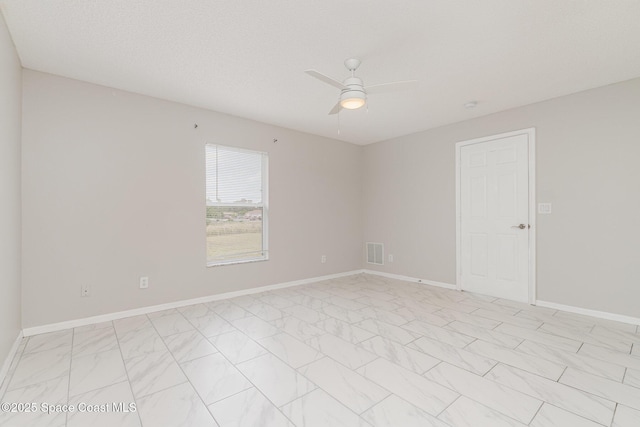 empty room featuring baseboards, a ceiling fan, visible vents, and marble finish floor