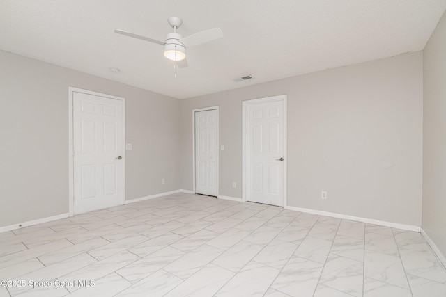 unfurnished bedroom featuring a ceiling fan, a closet, marble finish floor, baseboards, and visible vents
