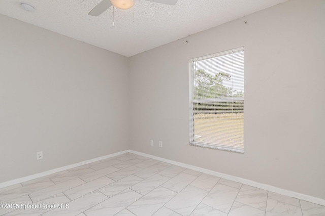 unfurnished room with a ceiling fan, baseboards, and a textured ceiling