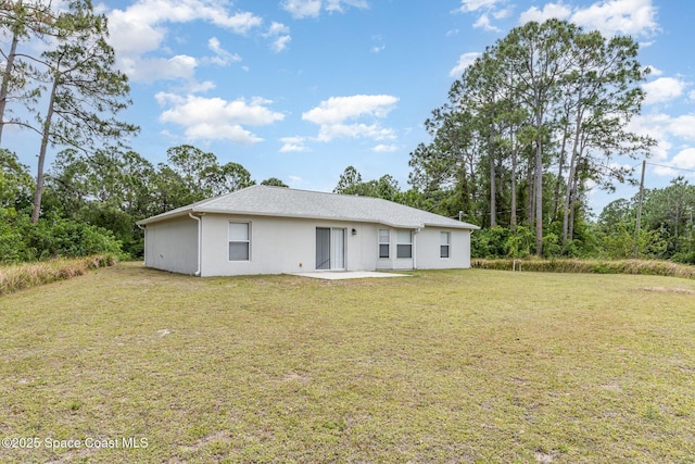 rear view of property with a yard and stucco siding