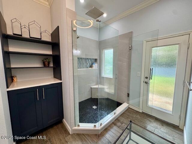 572 Lake Ashley Cir, Melbourne, FL 32904 - full bathroom featuring crown molding, wood finished floors, a shower stall, and baseboards