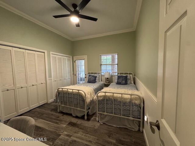 572 Lake Ashley Cir, Melbourne, FL 32904 - bedroom featuring dark wood-style flooring, crown molding, two closets, and a ceiling fan