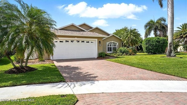 view of front of home featuring a front yard, stucco siding, a shingled roof, decorative driveway, and a garage