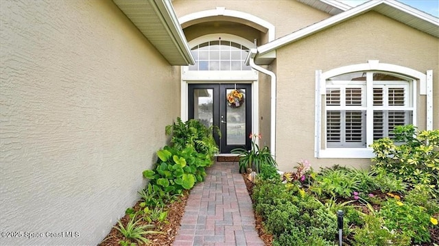 doorway to property featuring stucco siding and french doors