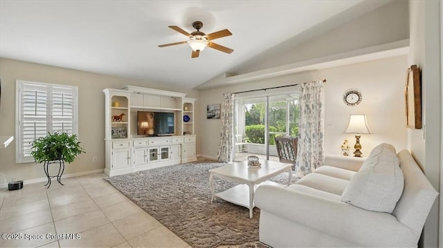 living area featuring baseboards, lofted ceiling, light tile patterned floors, and a ceiling fan