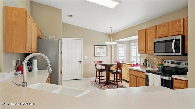 kitchen with vaulted ceiling, visible vents, stainless steel appliances, and light countertops