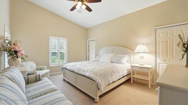 bedroom featuring light carpet, baseboards, lofted ceiling, and ceiling fan